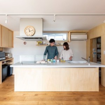シナ合板で統一された、カップボード、キッチン、パントリーが並ぶ。オープンなアイランドキッチンは空間を広く感じさせる。