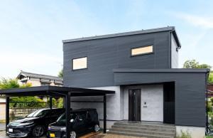 ダークトーンでシンプルにまとめられた外観。玄関の右手に見えるのは中庭へとつながる通路。