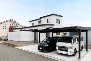 白い金属サイディングと黒いサッシのコントラストが美しいモダンな外観。テラスを取り囲む壁が外側に突き出したデザインもユニーク。
