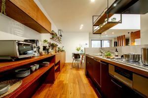 パナソニックのアイランドキッチンと、ワイドな造作棚を組み合わせたカフェライクな仕上がり。