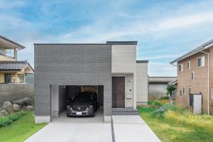 電動シャッター付きのインナーガレージを備えたシンプルな平屋。