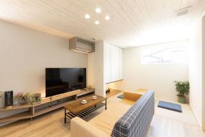 空間と一体に造られた幅広のテレビボードは間接照明付き。エアコンが目立たないようにルーバーが取り付けられている。