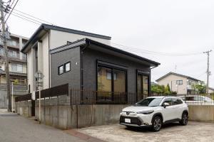 駅の近くで人目に付く角地であることを考慮した、白と黒の2色使いのスタイリッシュな外観。海に近いエリアのため、外壁には塩害に強い窯業系サイディングを採用。