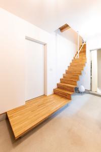 店舗側からも入れる玄関はゆとりある空間。踏み板と蹴込み板だけで構成された階段が美しい。