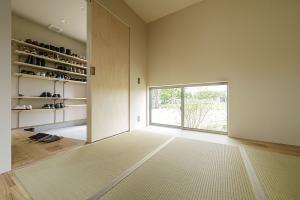 客間として玄関脇に設けた4畳弱の和室は奥様のこだわり。仕切り戸を引けば個室になる。窓から見えるツツジは目隠しにも。
