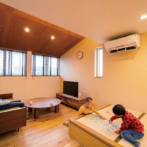 勾配天井によって空間にゆとりが感じられる2階リビング。床暖房の採用でお子様たちは冬でもはだしで過ごしているそう。畳スペースはお子様たちが遊ぶにも最適。下部は収納として活用している。