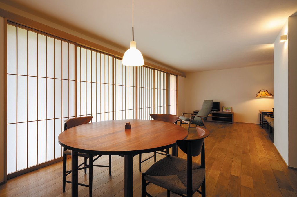 縦のラインを強調した障子が目を引く。ダイニングテーブルは長岡市の家具工房nine製。椅子やソファは北欧のヴィンテージ家具。