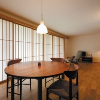 縦のラインを強調した障子が目を引く。ダイニングテーブルは長岡市の家具工房nine製。椅子やソファは北欧のヴィンテージ家具。