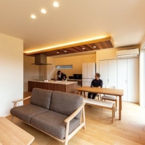 明るい色の床材はメープル材。家具も同系色でコーディネートしている。キッチン左奥には便利なサンルームがある。